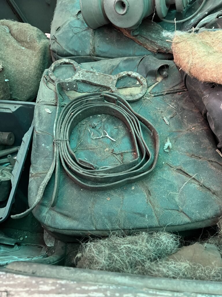 In front of car cabin extra small parts leather strapping and spanner